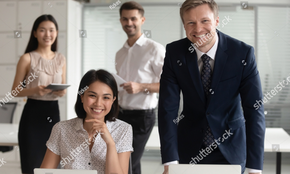 stock-photo-smiling-diverse-business-leaders-managers-posing-with-computers-and-team-people-in-office-1410209894